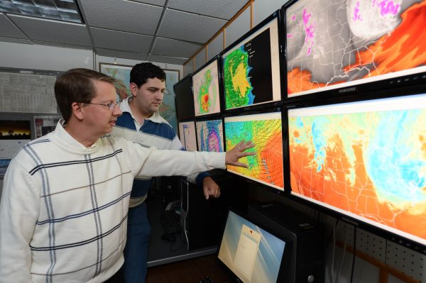 Dr. Gallus and student look at weather forecast maps.